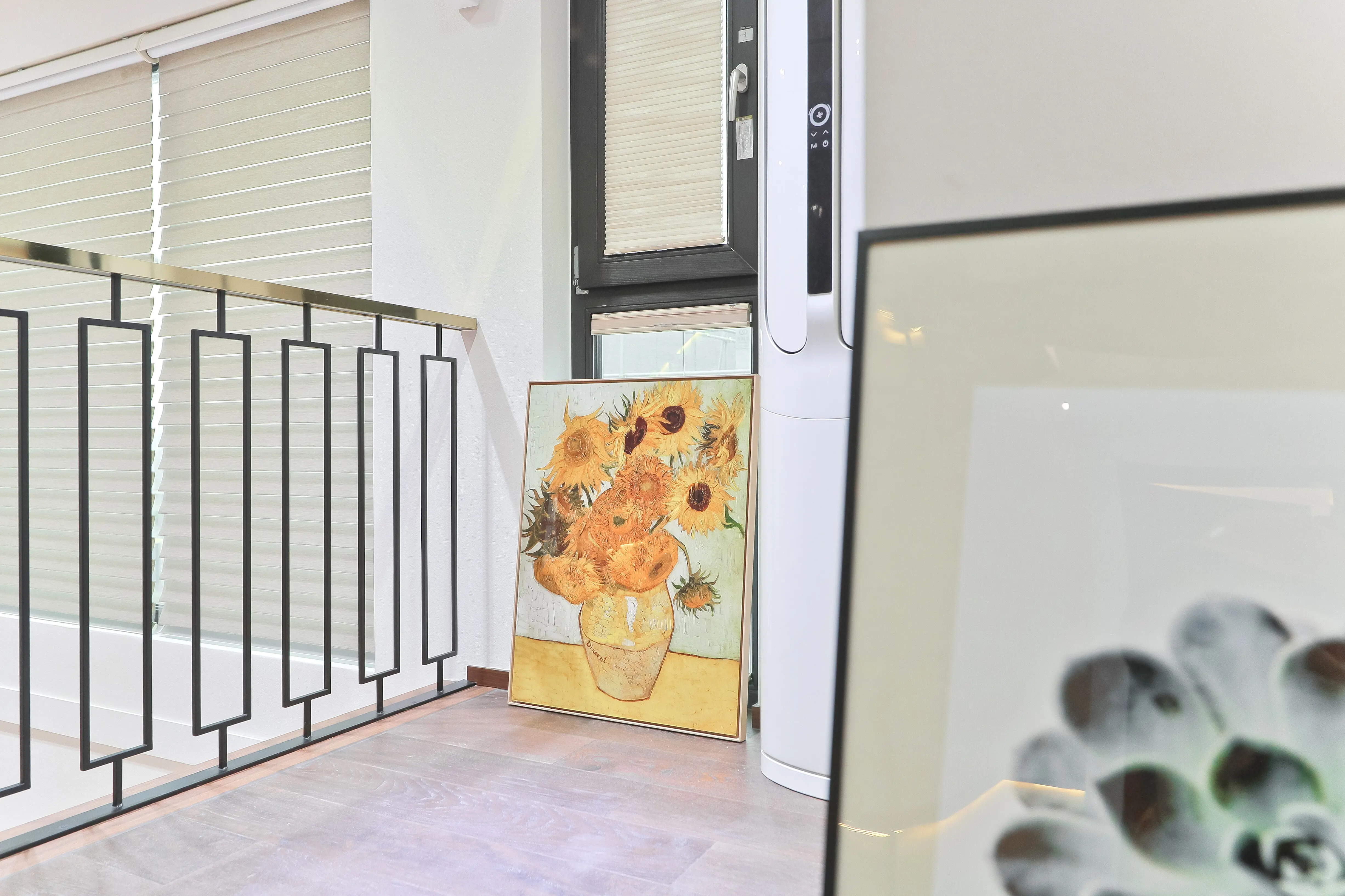 Ein Bild wurde in der Ecke des Wohnzimmers auf dem Boden platziert, um einen modernen Einrichtungsakzent zu setzen.